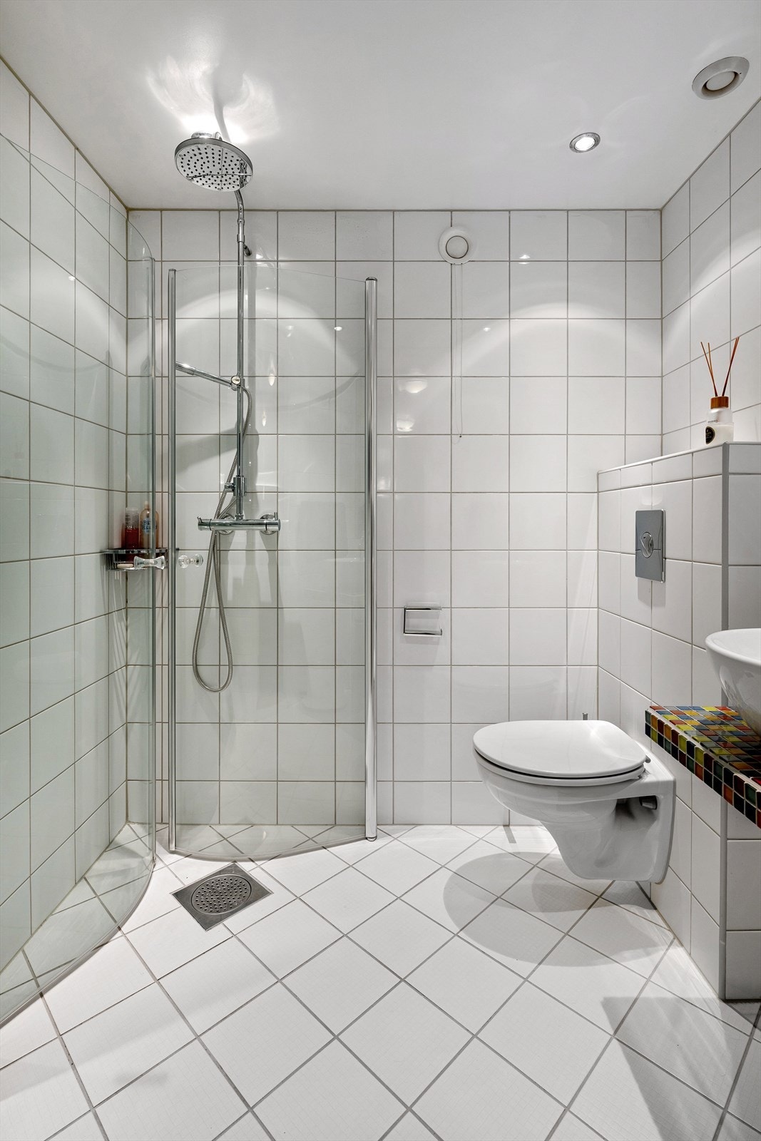 Bad i underetasjen med dusjhjørne, vegghengt wc, servant og speil. Galleribilde