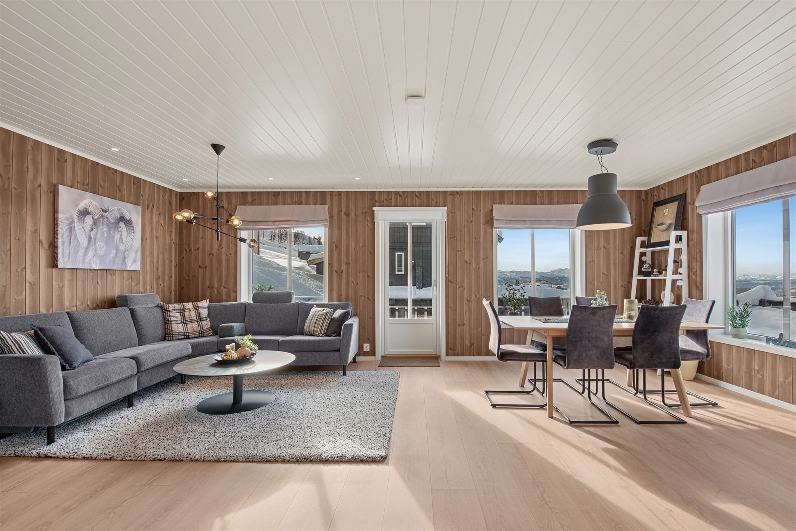 Stuen er romslig og pent utført i lyse toner, med store vindusflater som slipper inn rikelig med naturlig lys. Rommet har en god og funksjonell planløsning hvor både sittegruppe og spisegruppe finner sine naturlige plasseringer Galleribilde