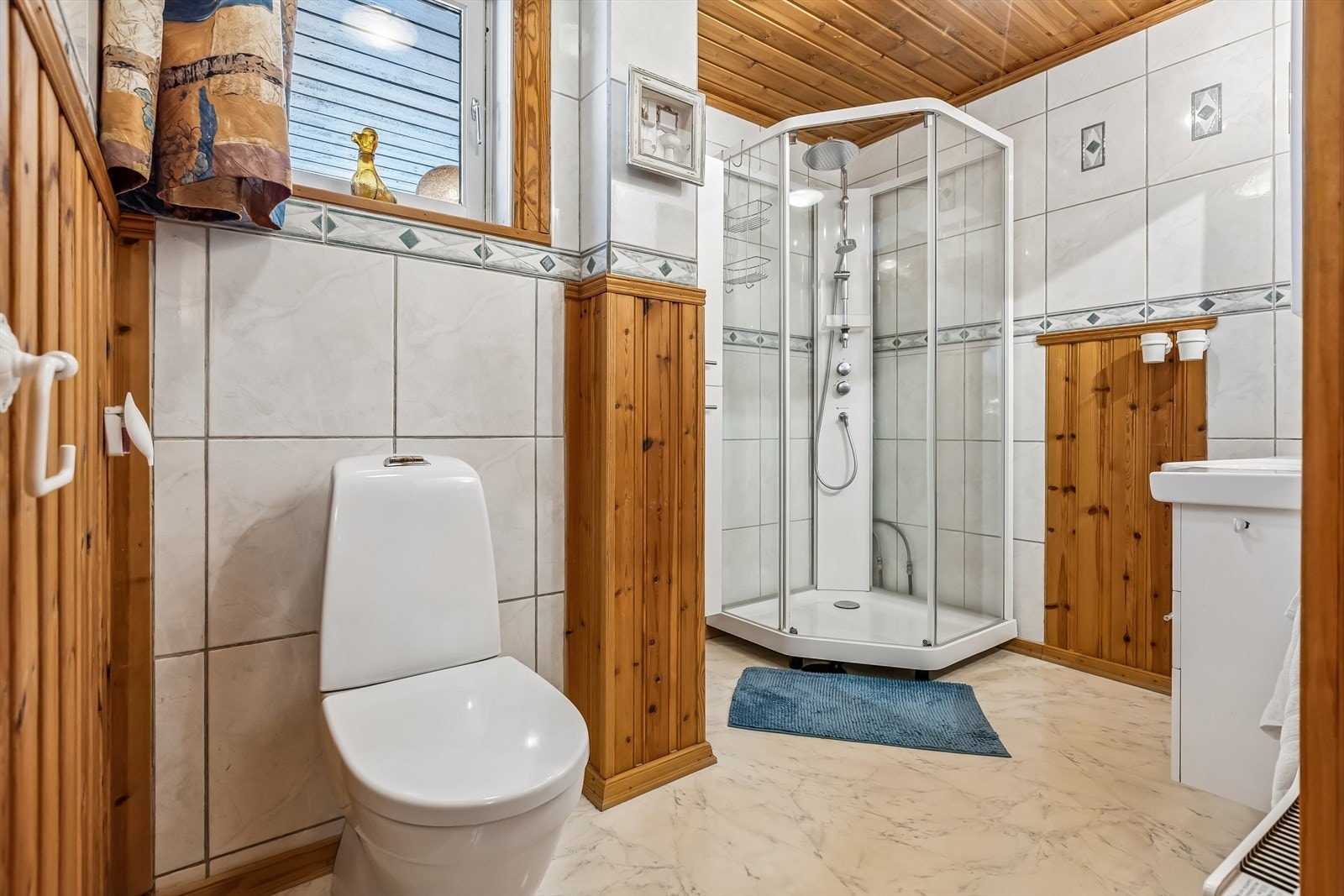 Badet er innredet med dusjkabinett, toalett og servantinnredning. Galleribilde