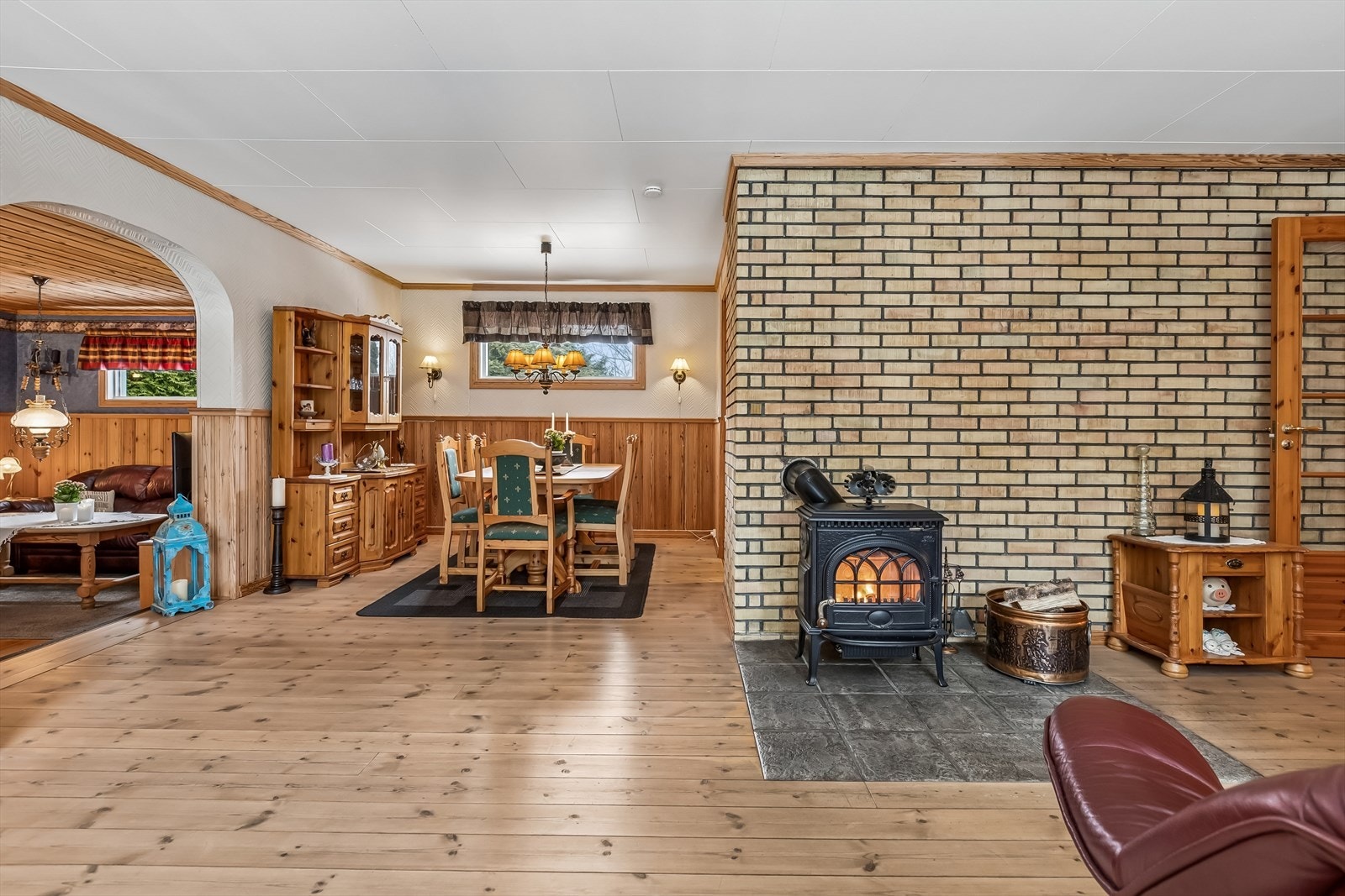 Vedovnen, plassert mot en teglsteinsvegg, gir en lun og god varme. Galleribilde