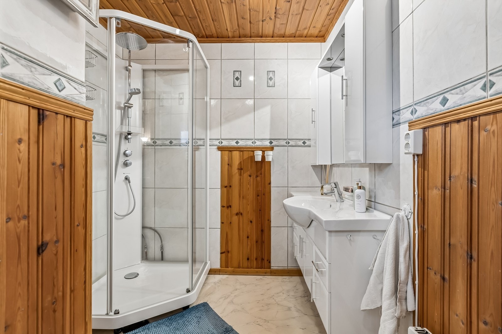 Vegger med en kombinasjon av fliser og panel, og vinylbelegg på gulv. Galleribilde