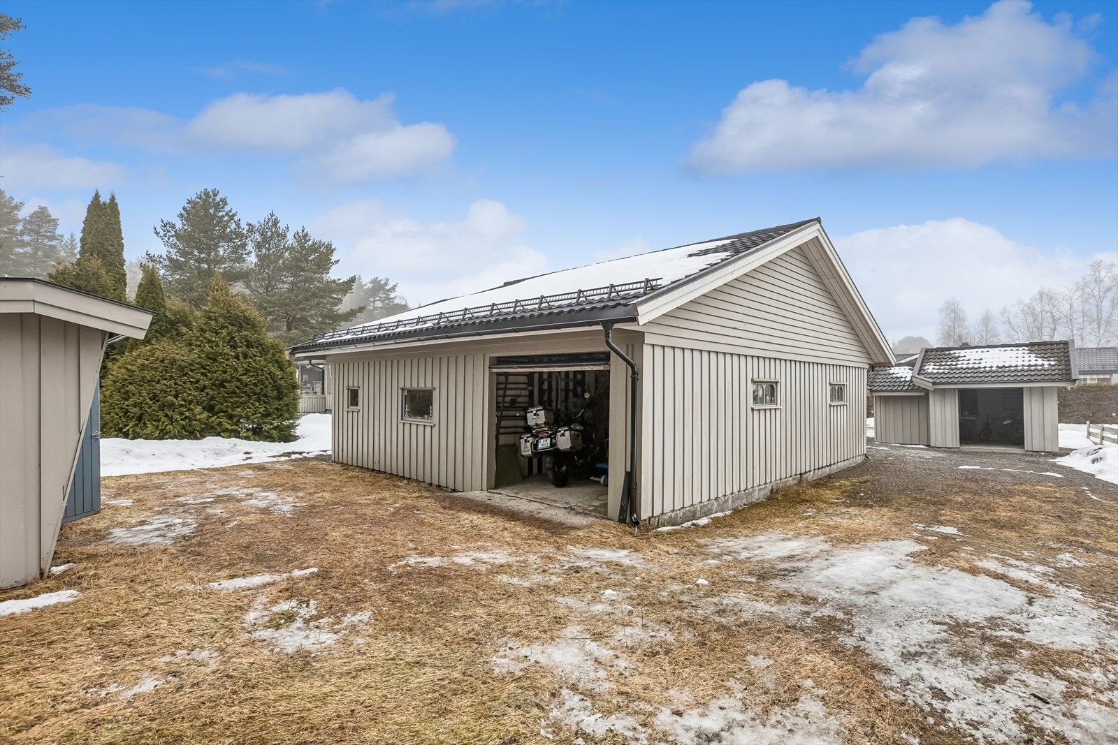 Garasjebygget på 68 m² har saltak tekket med stålplater og god lagringsplass på loftet. Galleribilde
