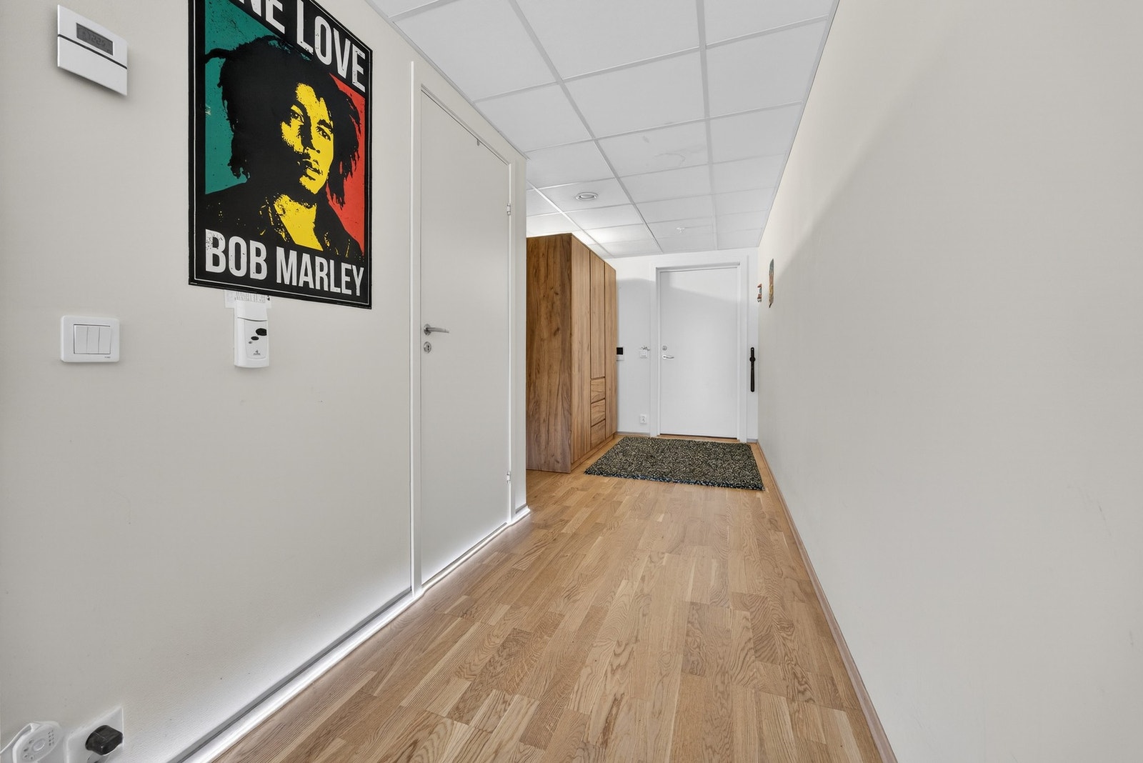 Tiltalende entré med trestavs parkett på gulv og lysmalte veggflater som gir et godt førsteinntrykk av leiligheten. Galleribilde