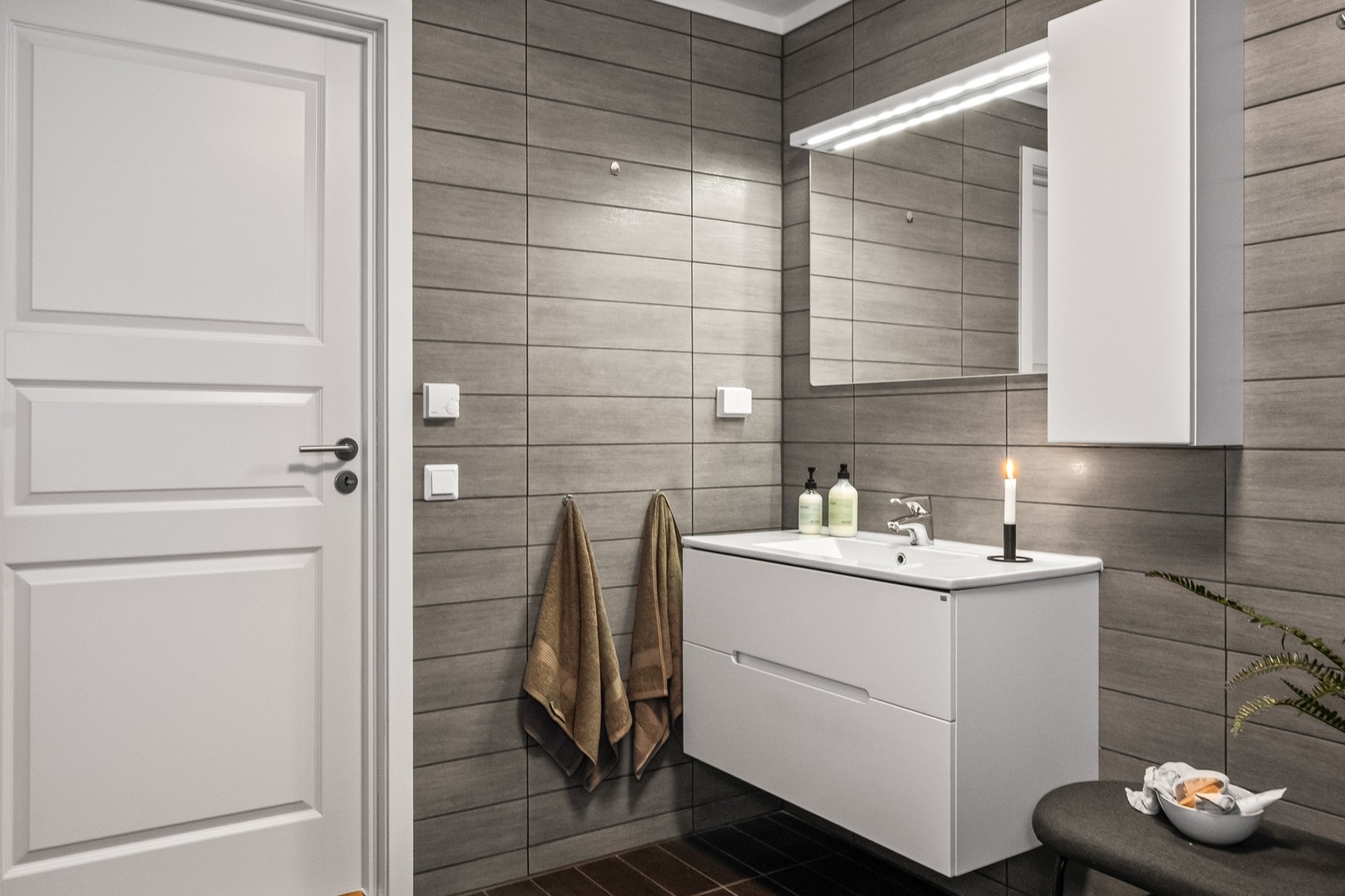 Badet fremstår delikat og moderne, med flislagte overflater og vannbåren gulvvarme som gir god komfort. Galleribilde