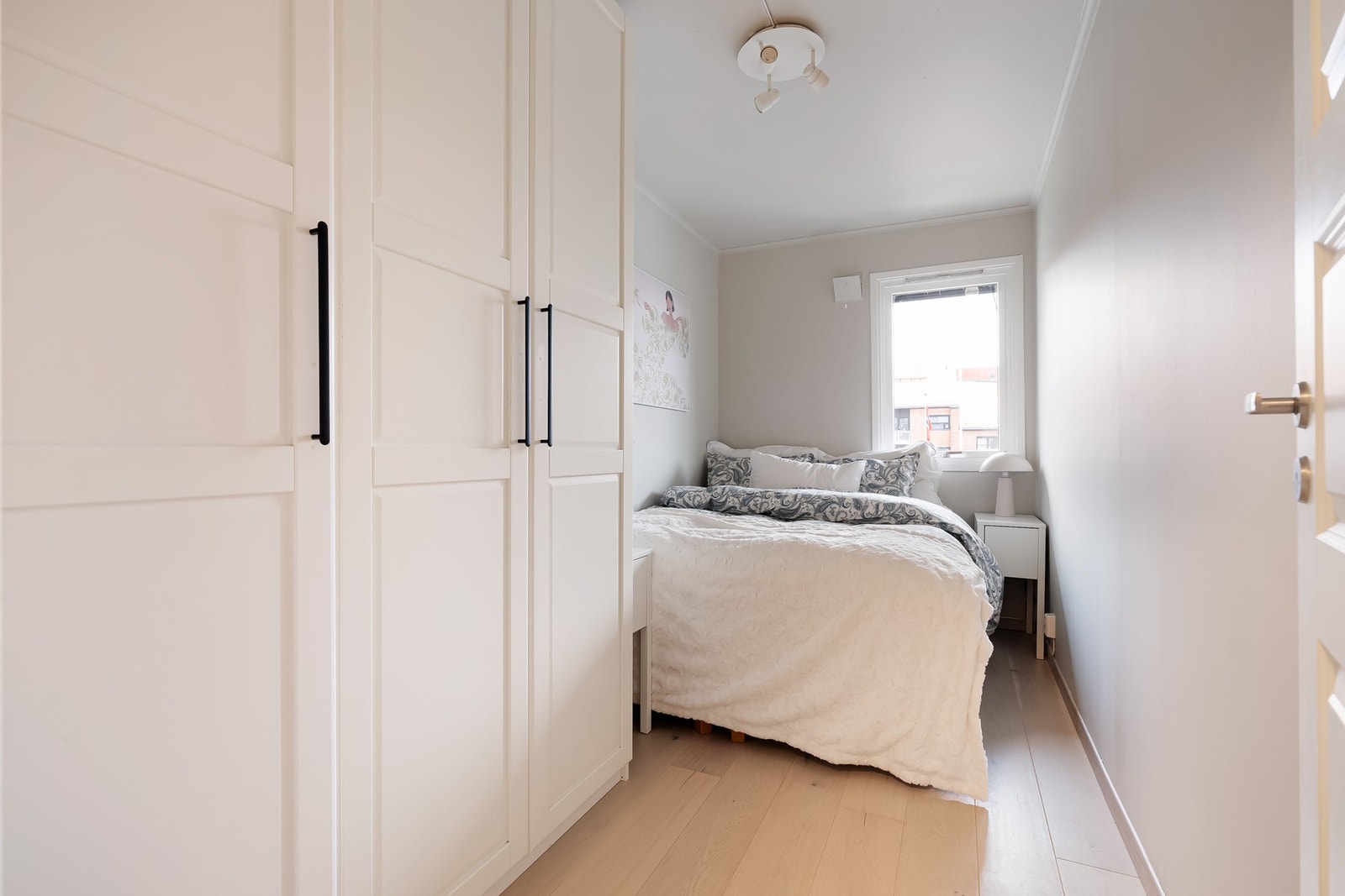 Lyst soverom med fin plass til dobbeltseng og nattbord. Galleribilde