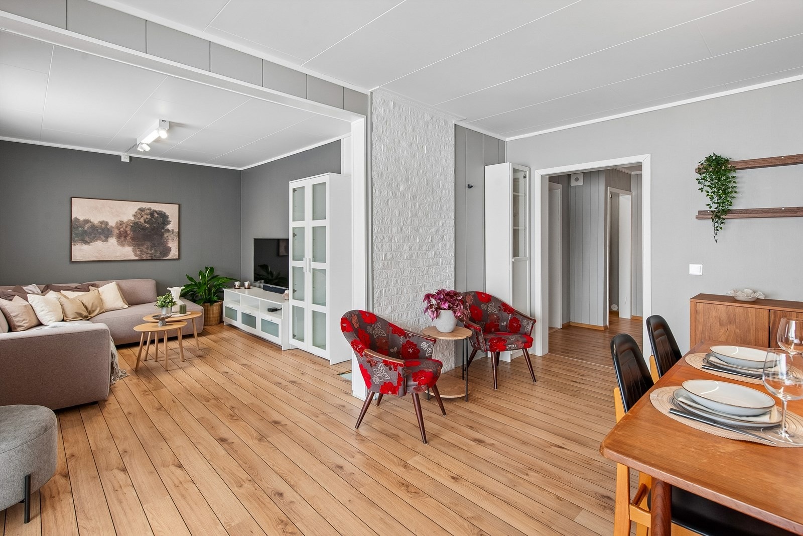 Stuen er et romslig og sentralt rom med laminatgulv og malte panelplater på veggene. Galleribilde