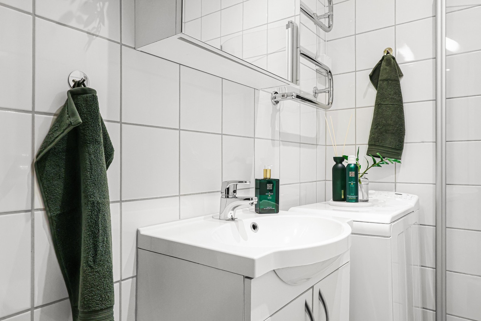 Badet er videre innredet med vegghengt servantskap med heldekkende servant og ett-greps armatur i krom. Det er opplegg for vaskemaskin og veggmontert elektrisk håndkletørker. Galleribilde