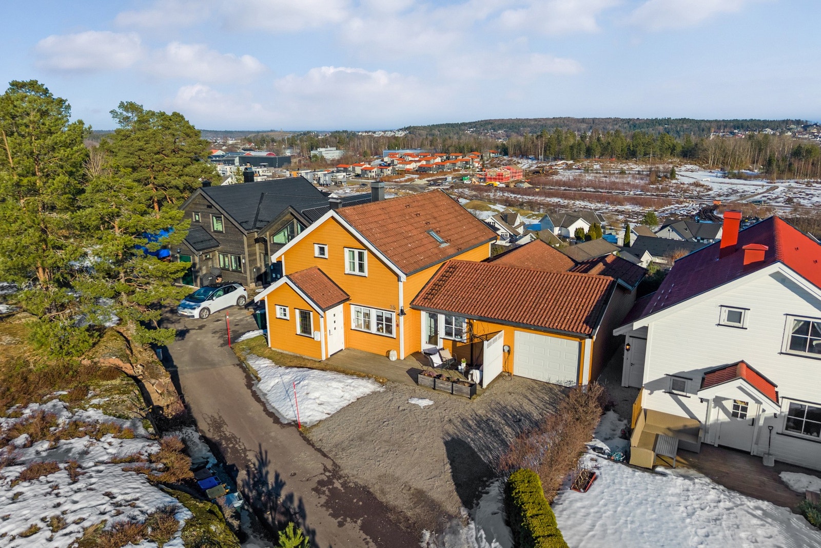 Tomten er pent opparbeidet med plenarealer, busker, hekker og variert beplantning. Galleribilde