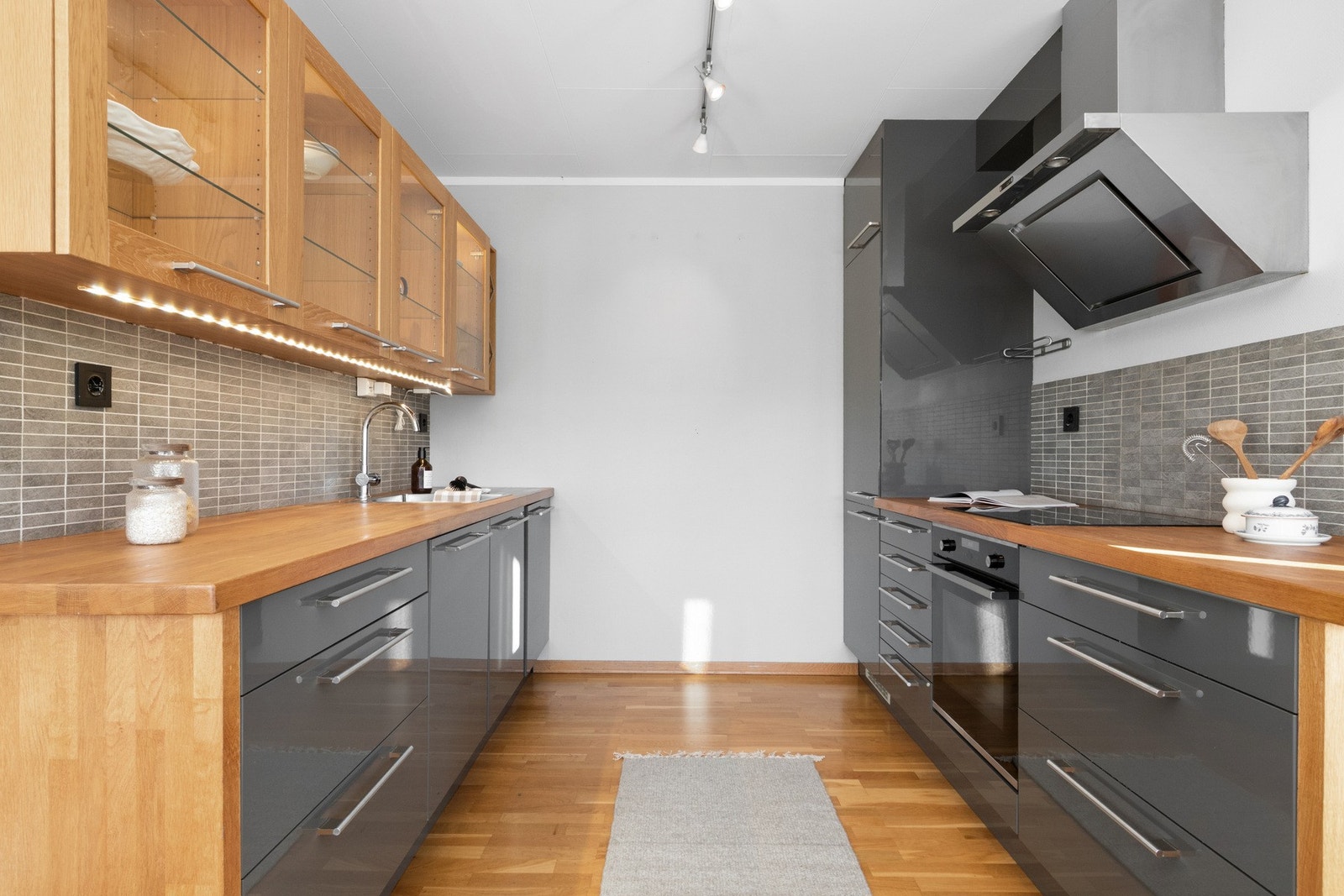 Kjøkkeninnredningen er fra 2009 og har grå, glatte fronter, vinhyller, heltre benkeplate, nedfelt oppvaskkum samt vitrineskap med integrert belysning. Galleribilde