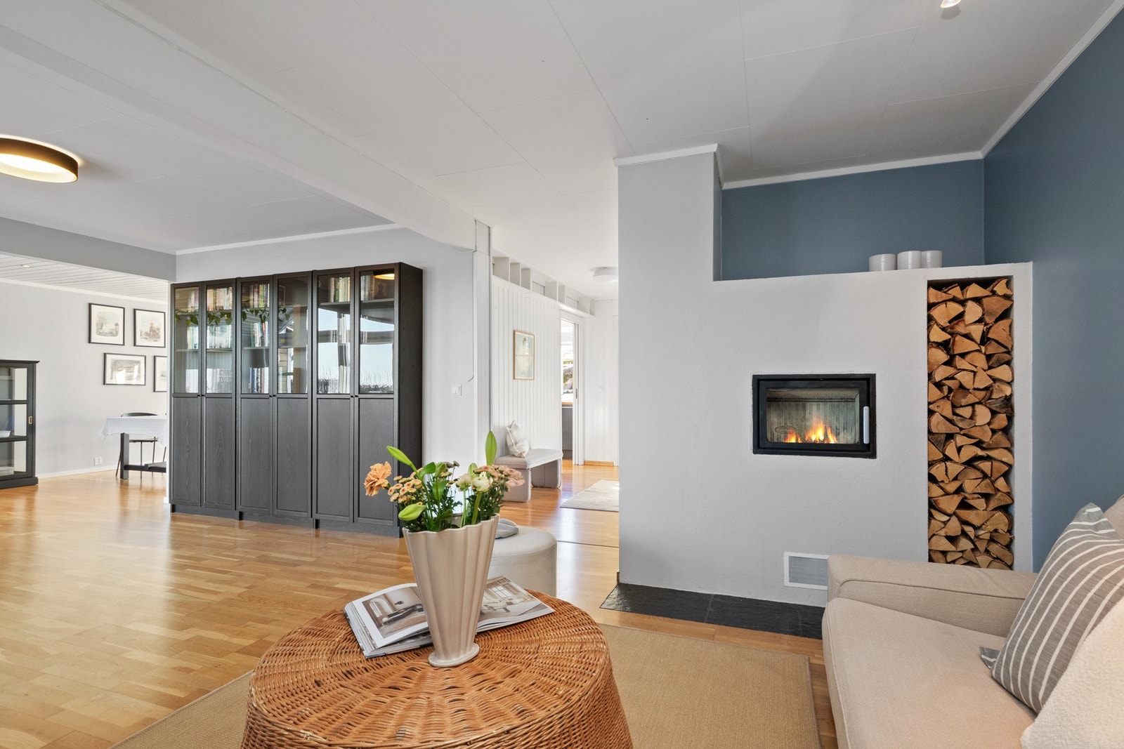 Innerst i oppholdsrommet er det innredet en tv-stue med plass til tv-krok og peis foran et moderne ildsted i hvitt design. Galleribilde