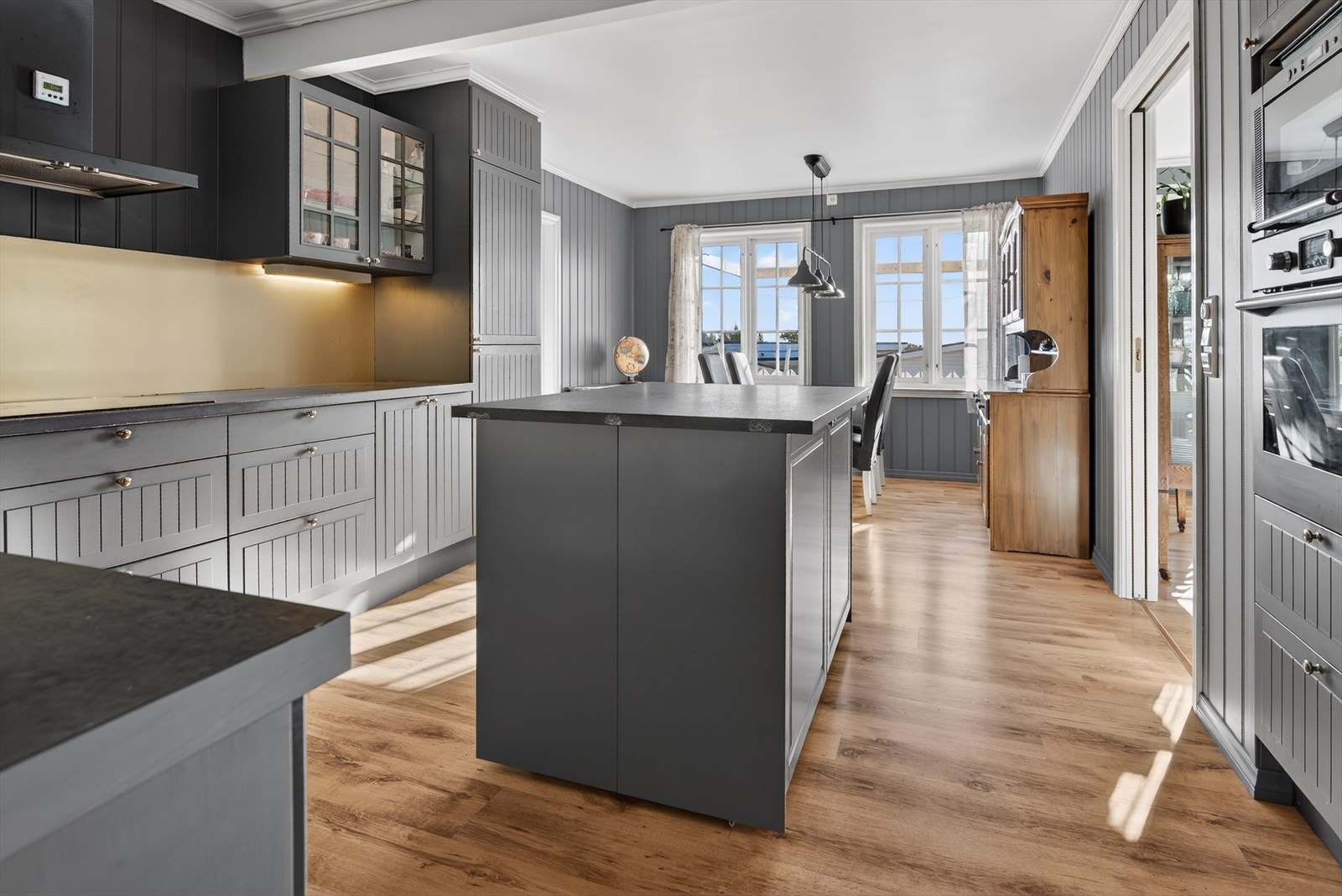 Delikat kjøkken med romslig innredning og integrerte hvitevarer Galleribilde