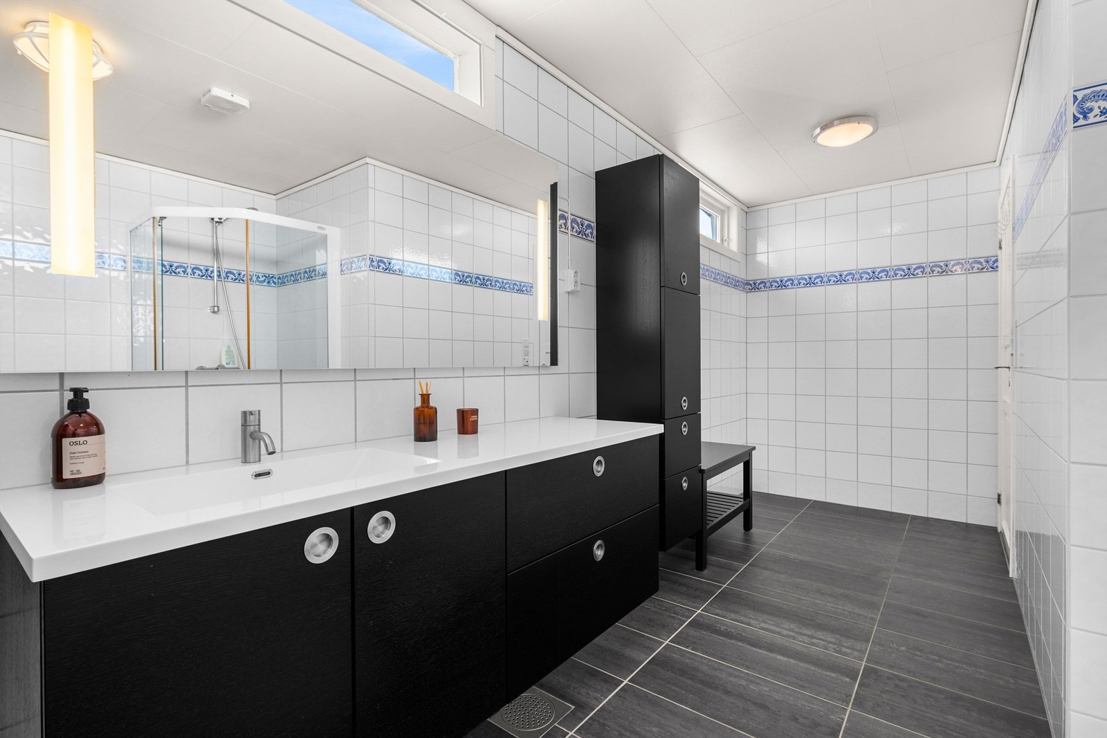 Flislagt bad med gulvvarme og praktisk servantinnredning fra 2013. Rommet har en funksjonell utforming som gir god flyt i hverdagen. Galleribilde