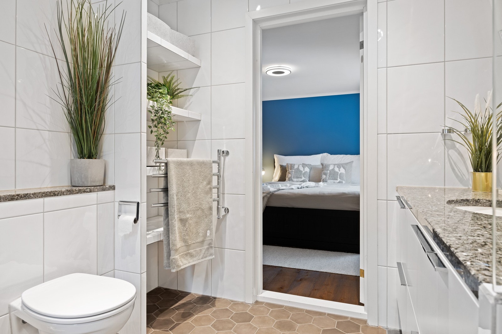 Vegghengt toalett, integrerte hyller og elektrisk håndklevarmer i badet i 1. etasje Galleribilde