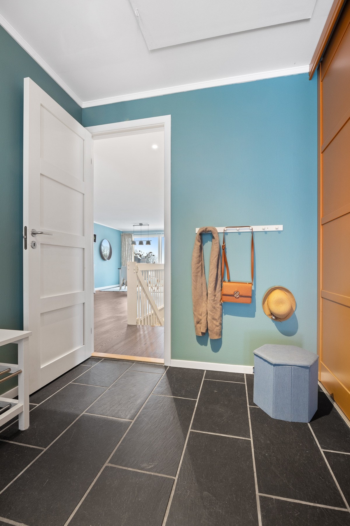 Romslig entré med fliser og varmekabler i gulvet. I den store skyvedørsgarderoben er det både hyller, skuffer og plass for oppheng. Galleribilde