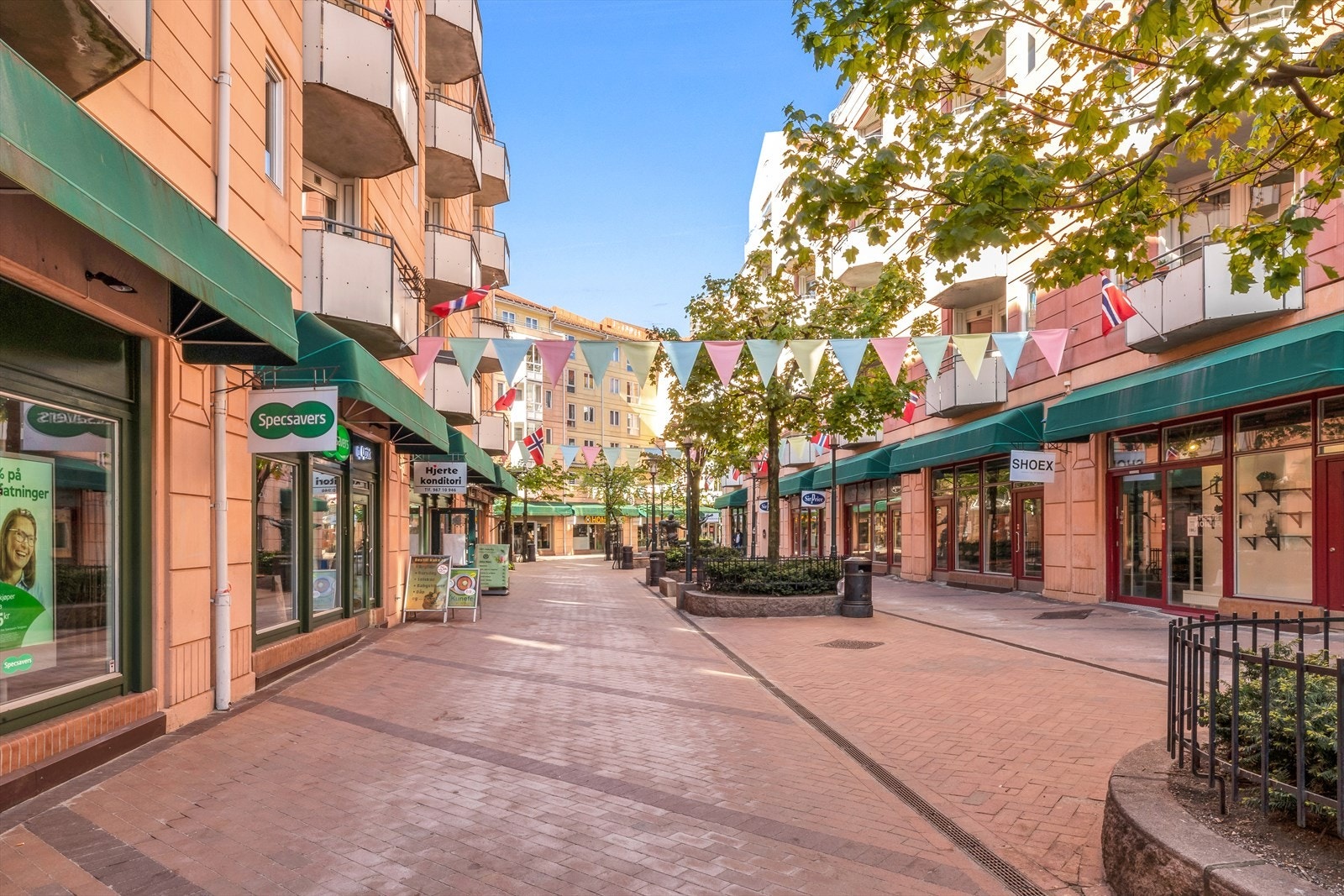 Smalgangen er en koselig gate brosteinsbelagt og beplantet med diverse buskevekster og blomster. Galleribilde