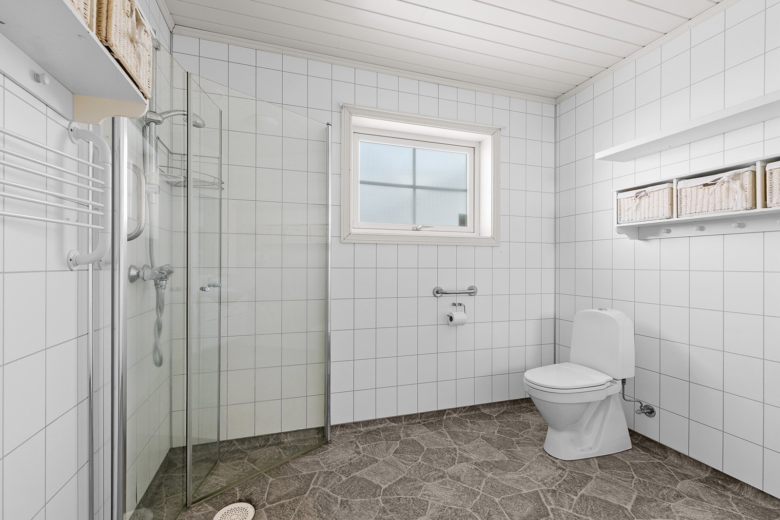 Romslig bad med wc, dusjhjørne og håndvask med skap Galleribilde