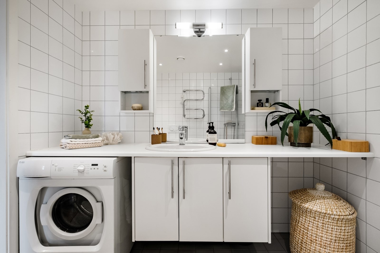 Badet er innredet med en nedfelt servant, overhengende speil og belysning. Galleribilde