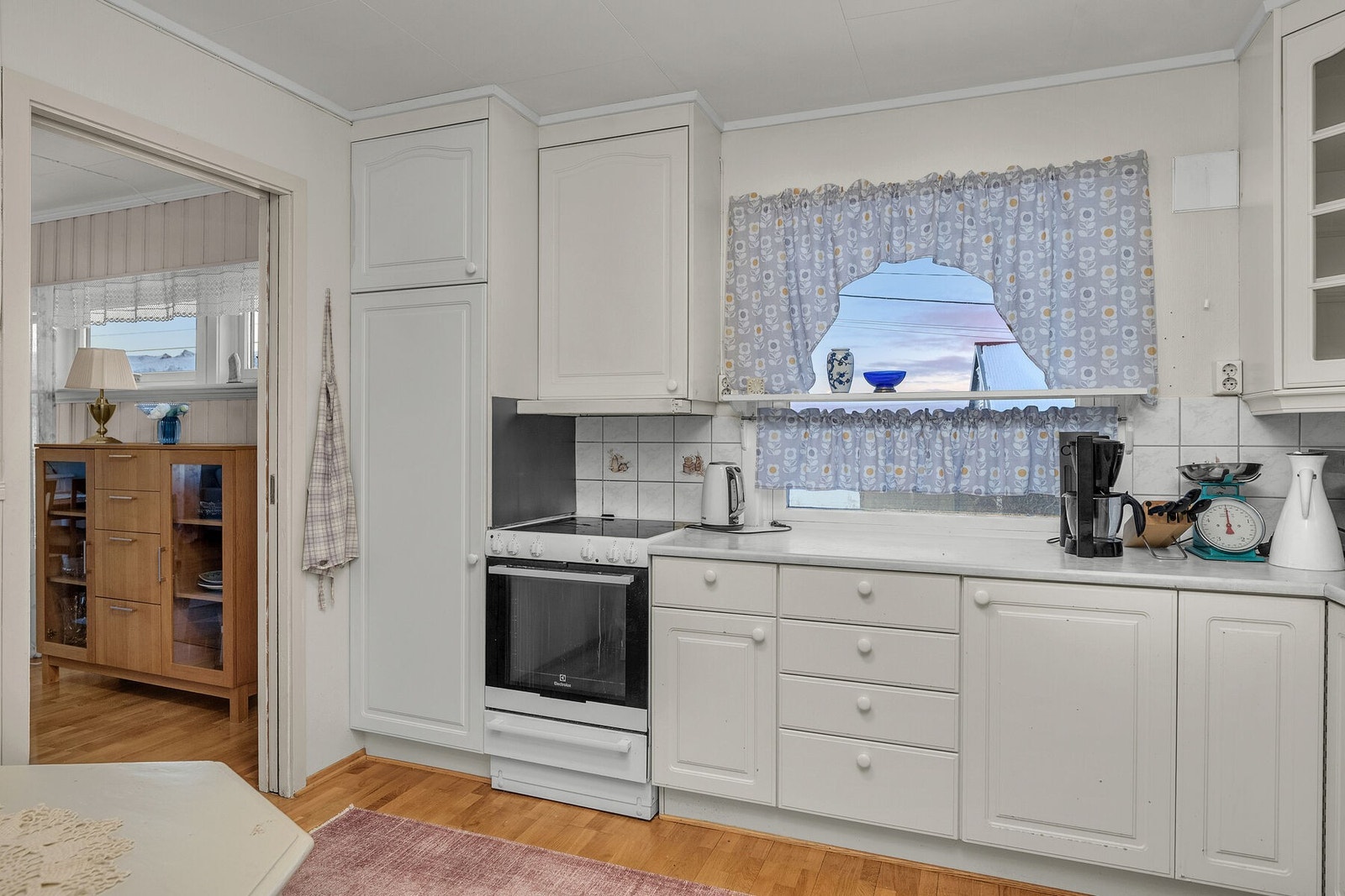 Kjøkkenet har lyse profilerte fronter, laminat benkeplate og ventilator med avtrekk til yttervegg. Galleribilde