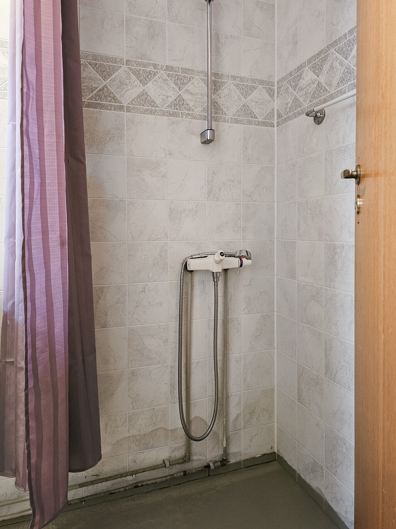 Baderommet er utstyrt med toalett, servant, dusj på vegg og provisorisk opplegg for vaskemaskin. Galleribilde