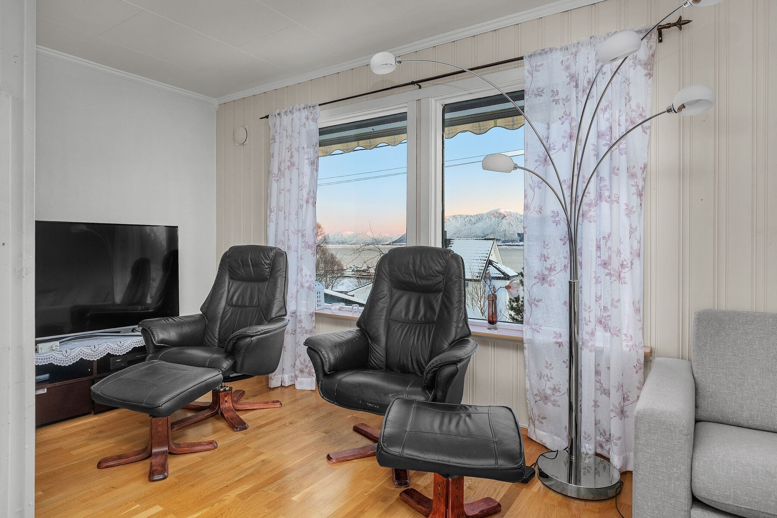 Deler av stue med nydelig utsikt mot sjø og fjell. Galleribilde