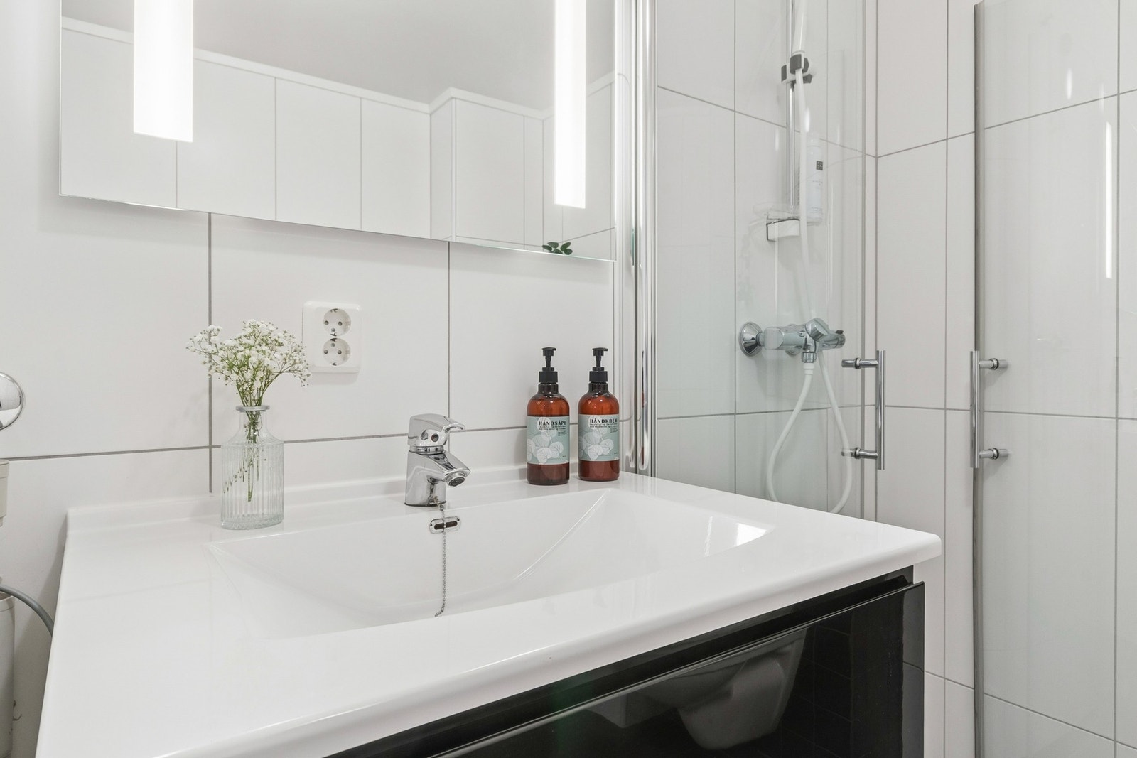 Flislagt bad/vaskerom med dusjhjørne, vegghengt WC og servantseksjon. Opplegg for vaskemaskin og varmekabler i gulv. Galleribilde