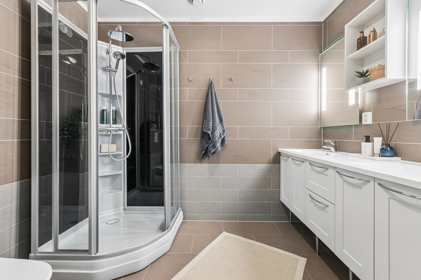 Flislagt bad i 3. etasje med stilren innredning. Servantseksjon, dusjkabinett og toalett - med elektriske varmekabler i gulv. Galleribilde