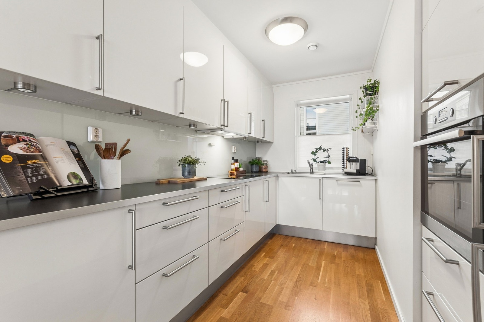 Kjøkkenet ligger i åpen løsning mot spisestuen, og har innredning med hvite glatte fronter og benkeplate i laminat. Galleribilde