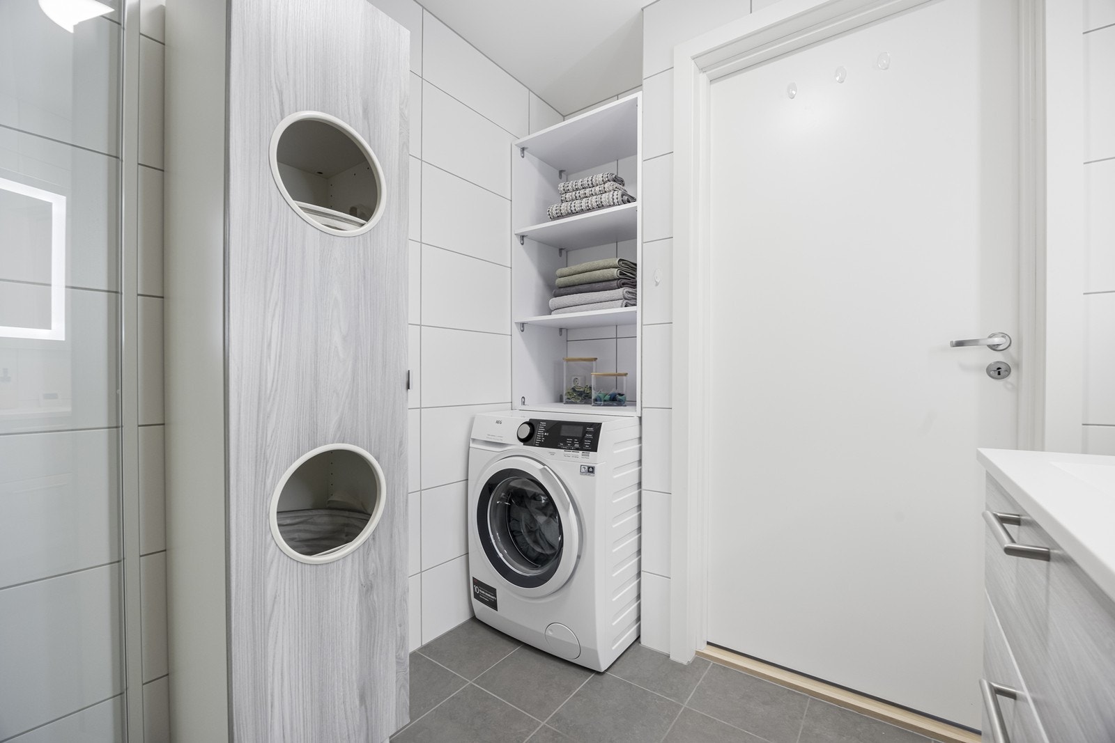 Praktisk nisje med plass til vaskemaskin og tørketrommel. Hylle over vaskemaskin er satt opp fpr ekstra oppbevaring og kan medfølge om ønskelig. Galleribilde