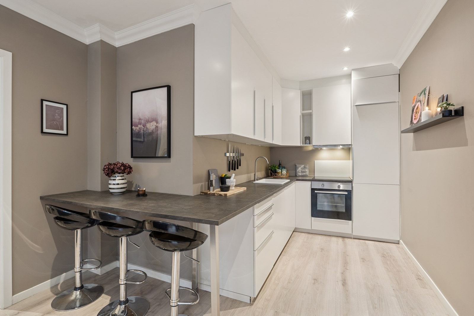 Kjøkkenet er praktisk innredet med skap helt opp mot taket og god benkeplass. Galleribilde