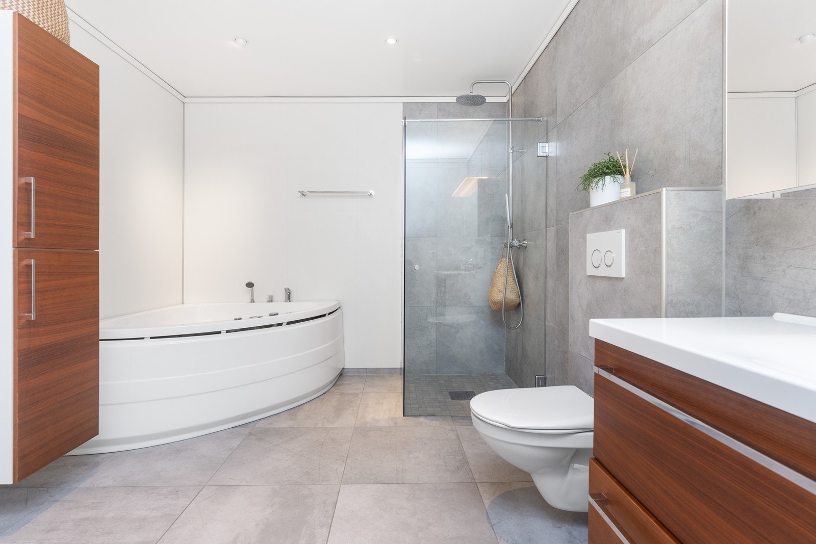 Innredet med stort badekar, baderomsinnredning, vegghengt toalett og dusjhjørne. Galleribilde