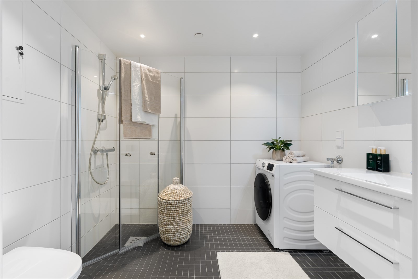 Baderommet er på 5 m² og har innredning levert av HTH. Badet er flislagt fra topp til tå med varme i gulv og har moderne downlights i tak. Baderomsinnredningen har god plass til lagring av både håndduker og andre baderomsartikler. Galleribilde