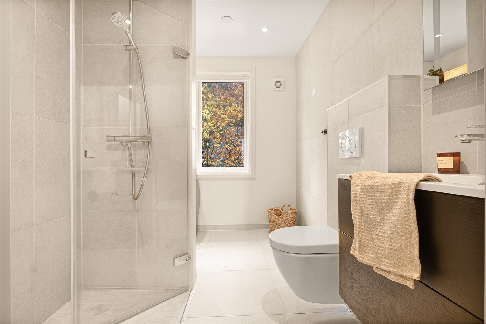 Lyst og lekkert bad fra 2020 med varmekabler i gulv. Downlights i himling, mekanisk avtrekksvifte og fordelerskap for rør-i-rør system. Galleribilde