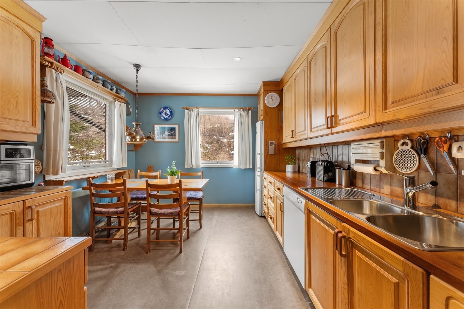 Kjøkkenet har over- og underskap, benkeplate med nedfelt kum i stål og platetopp. Galleribilde