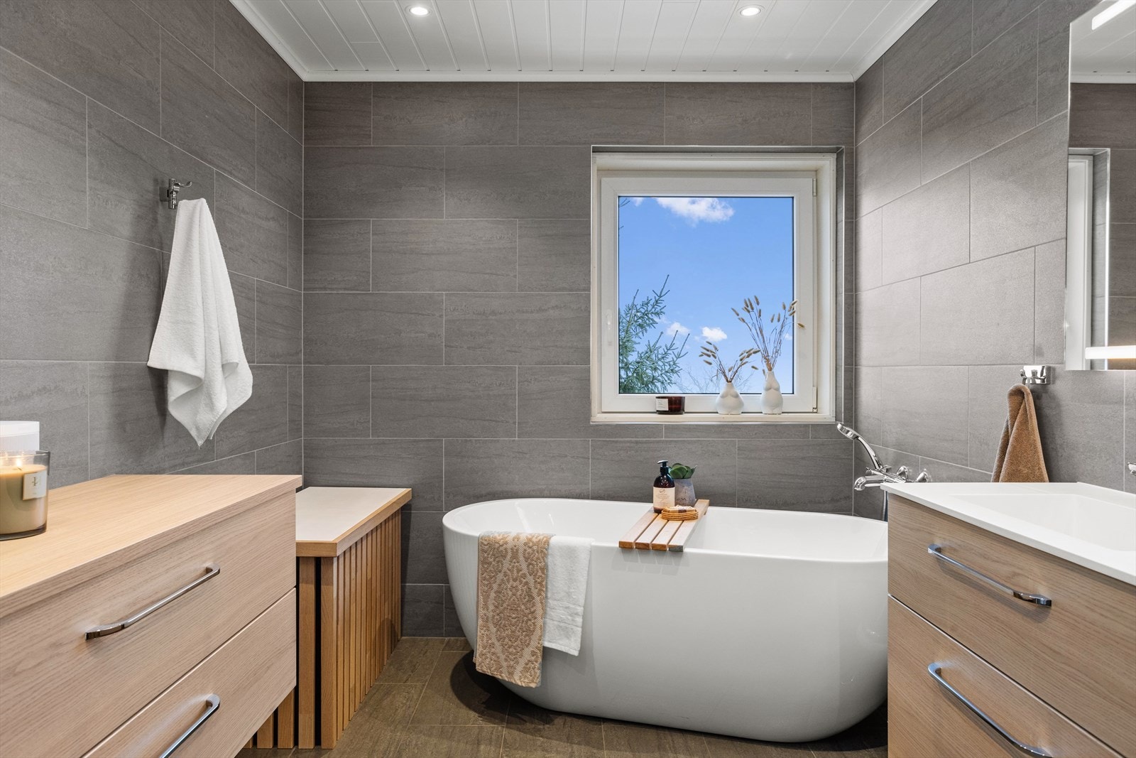 Badet har stilrene fliser med underliggende varme, og downlights i taket. Galleribilde