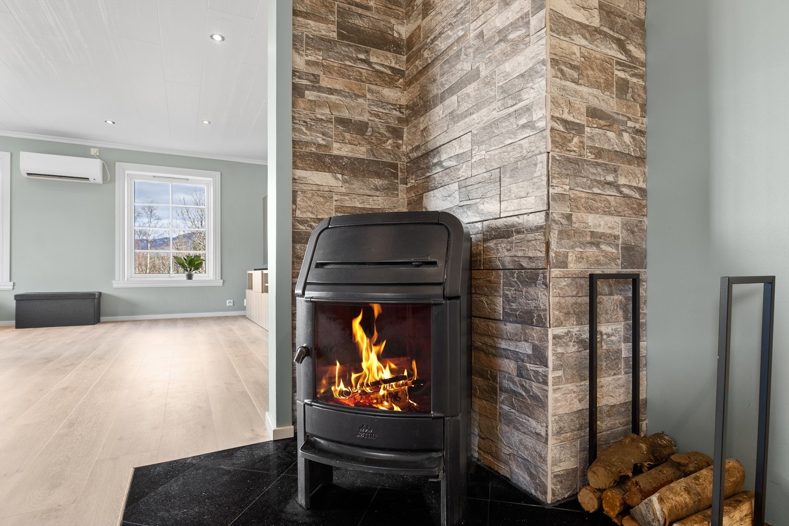 Stuen har en hyggelig atmosfære med koselig peisovn og nyere varmepumpe Galleribilde