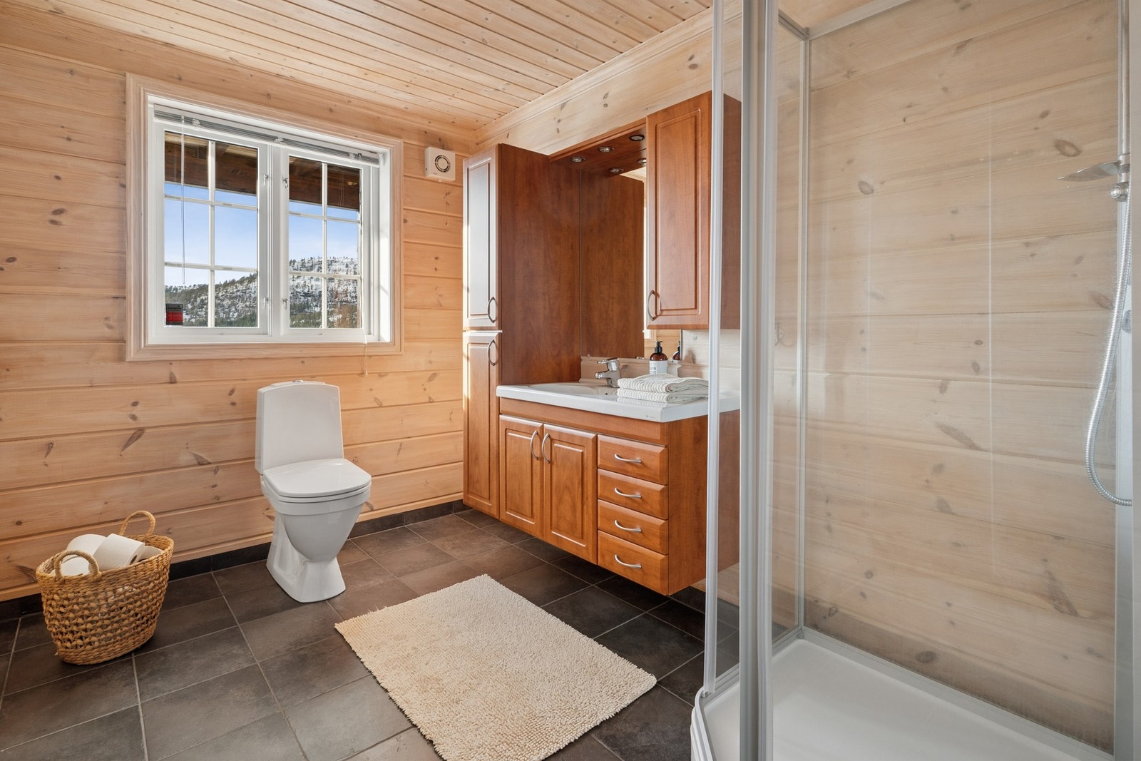 - Baderommet har gode oppbevaringsmuligheter. Badet er utstyrt med toalett og dusjkabinett - Galleribilde