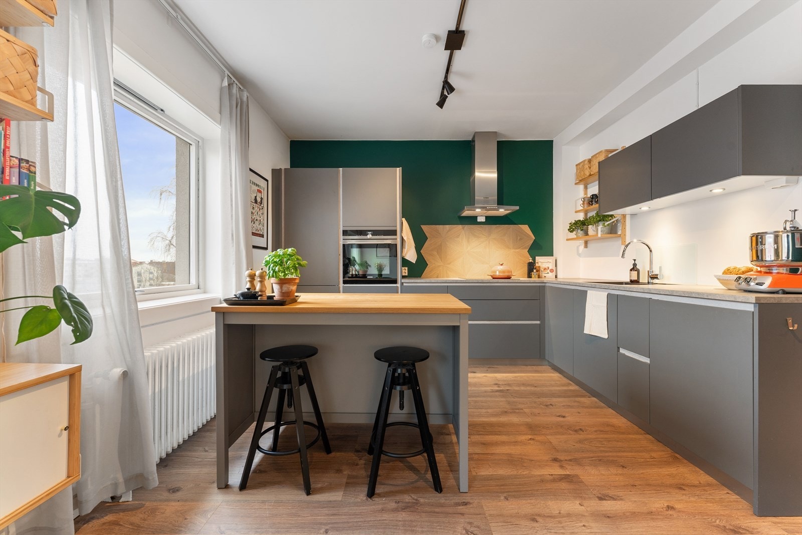 Kjøkkenet er utstyrt med veggmontert kullfilterventilator i stål, samt integrert induksjonstopp, stekeovn, oppvaskmaskin og kjøl/frys. Galleribilde