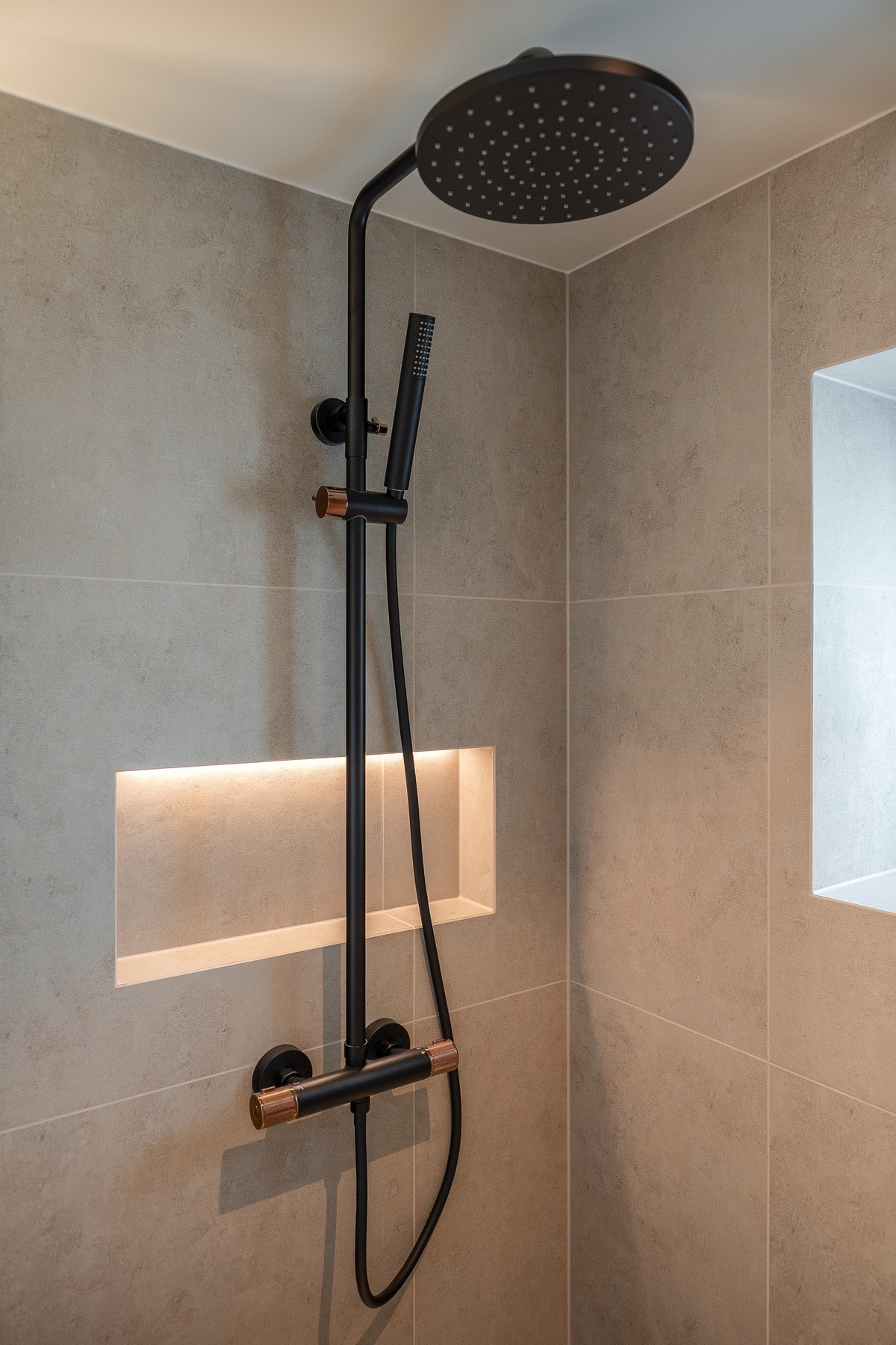 Flott regndusj som avgrenses med glassfelt. Egen nisje i veggen med LED-belysning hvor man har oppbevaring. Galleribilde