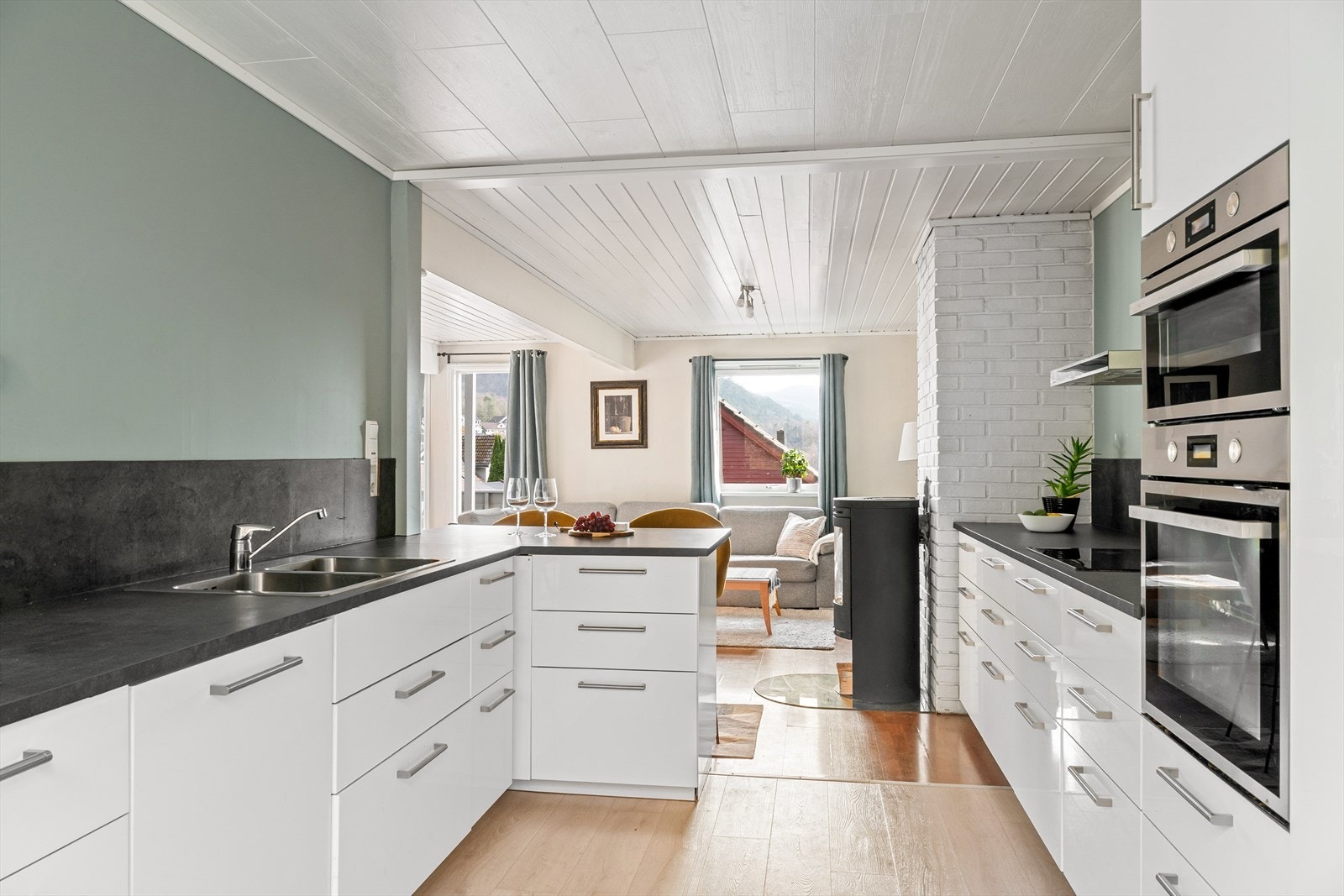 Kjøkkenet er av nyere dato og levert av IKEA. En åpen løsning mot stuen via en praktisk barløsning gir en naturlig overgang mellom rommene og fungerer godt som spiseplass eller samlingspunkt. Galleribilde