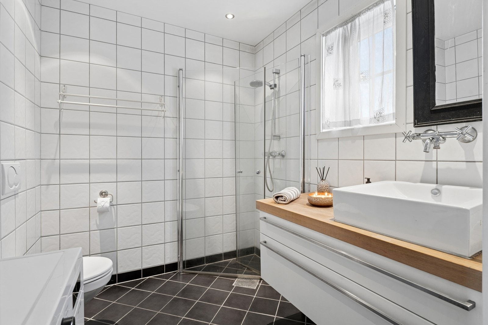 Praktisk bad og vaskerom i første etasje med gulvvarme, dusjhjørne og opplegg for vaskemaskin. Galleribilde