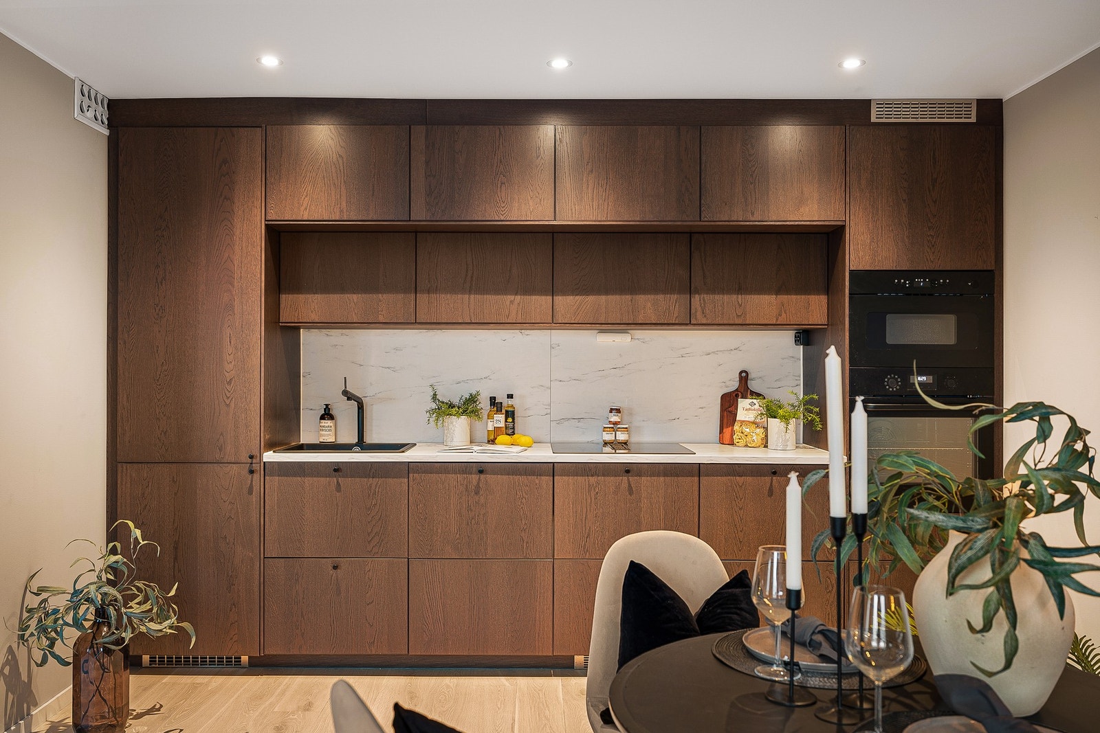 - Kjøkkenet er moderne og lekkert, med innredning i mørk eik med slette fronter og laminat benkeplate med komposittvask - Galleribilde