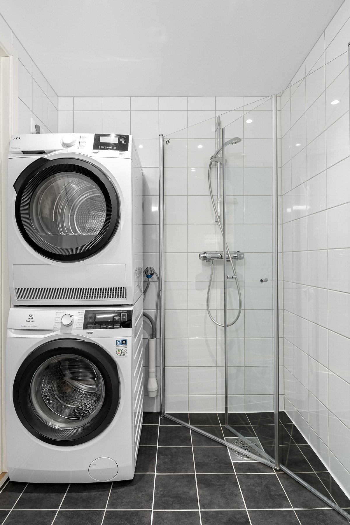 . Rommet er utstyrt med servantinnredning, vegghengt toalett og dusjhjørne. I tillegg har man opplegg for vaskemaskin og plass til tørketrommel. Galleribilde