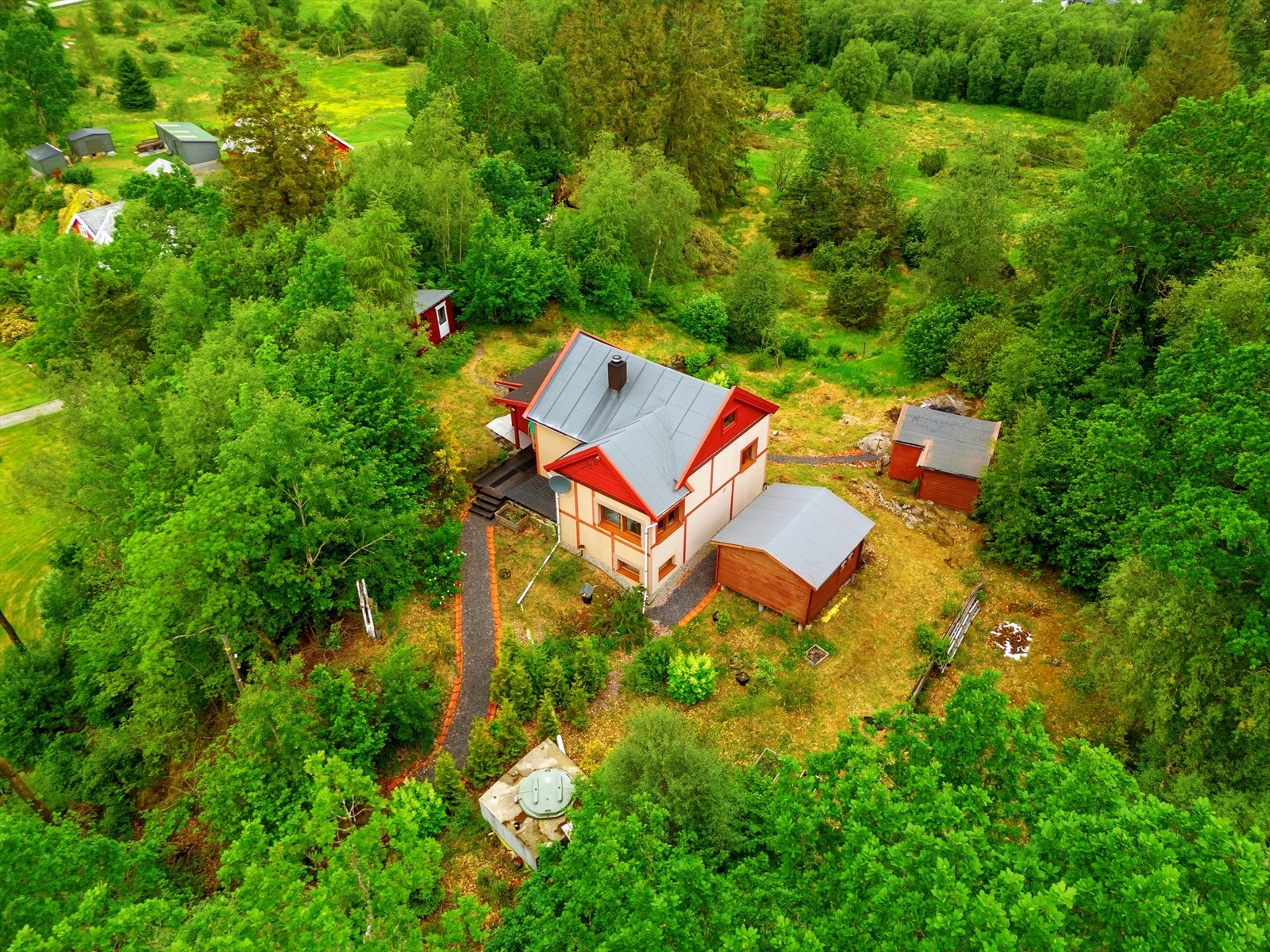 Tomten har en høy og fri beliggenhet bebygget med hytte og flere uteboder. Galleribilde