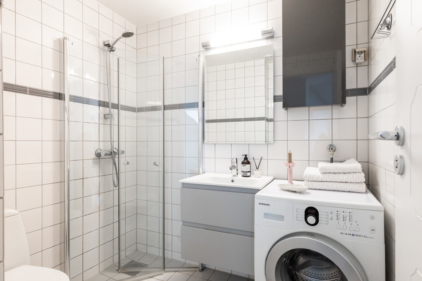 Leilighetens bad er av god størrelse og har flis på vegg/gulv og malte plater i taket Galleribilde