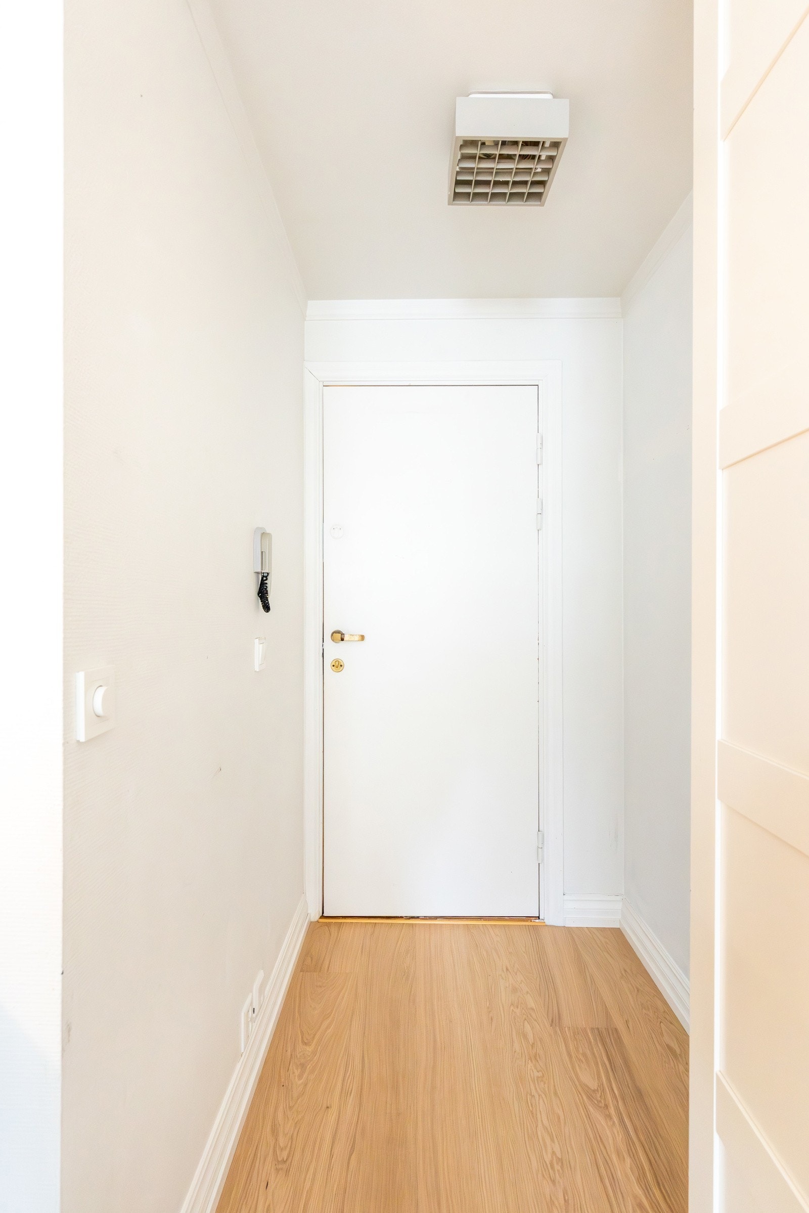 Man ankommer leiligheten i en innbydende entré med plass til oppheng av yttertøy på veggen Galleribilde