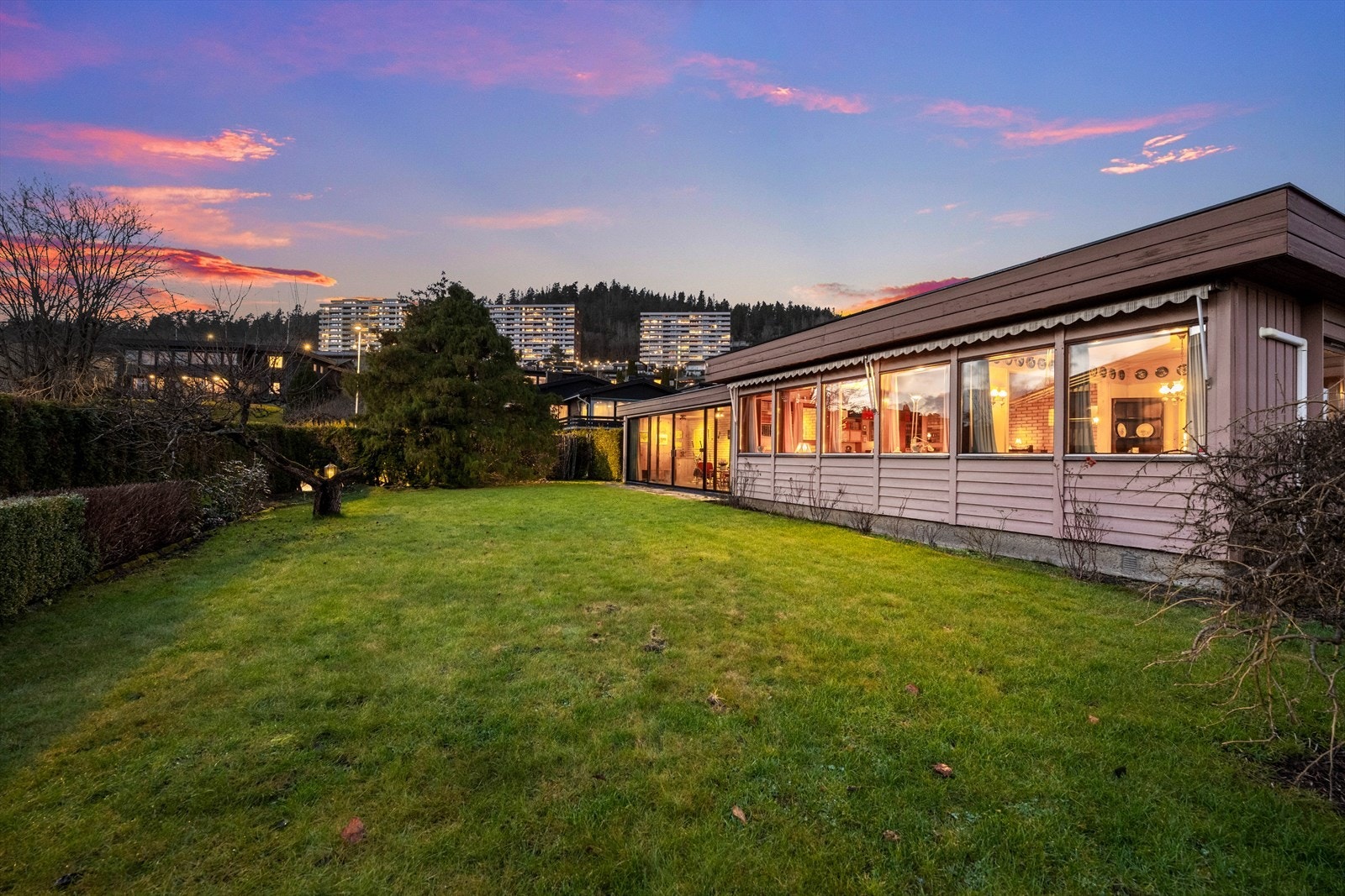 Eiendommen er pent opparbeidet med plenarealer, prydbusker, rhododendron busker og hekker som skaper en grønn og skjermet ramme rundt uteområdet. Galleribilde