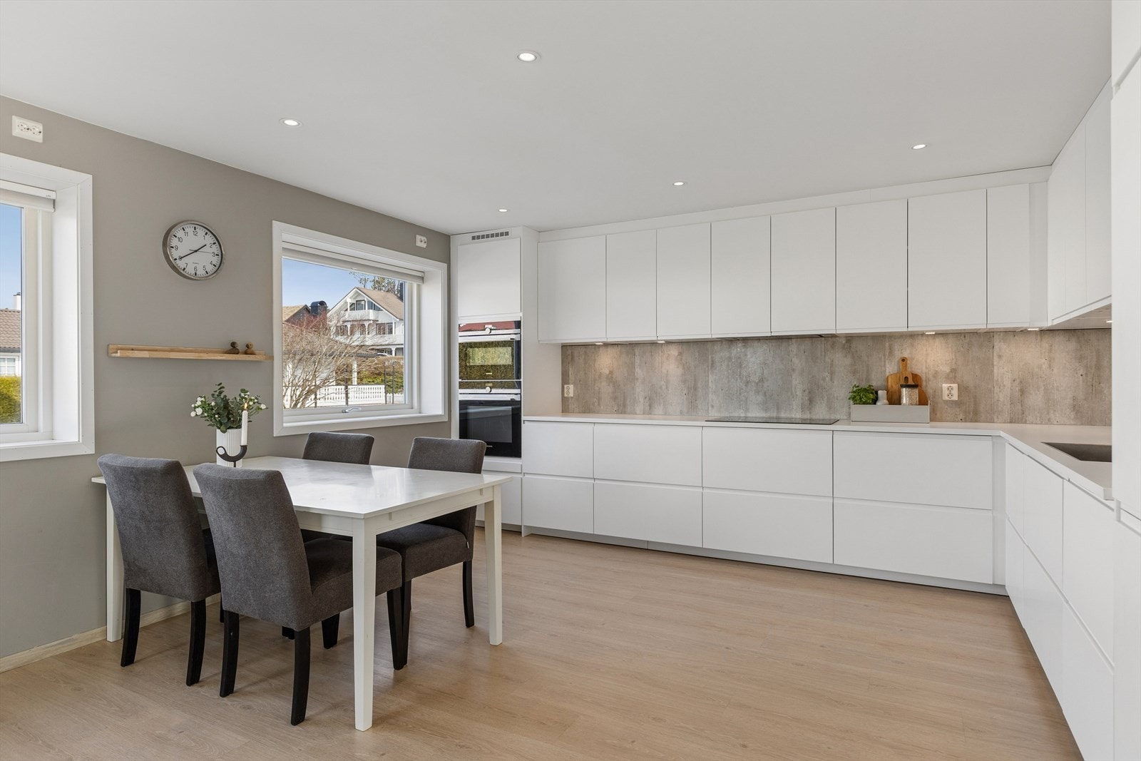 Moderne og funksjonelt kjøkken, innredning med glatte fronter og laminat benkeplate. Kjøkkenet er innredet slik at matlagingen forenes med sosialt samvær. Galleribilde