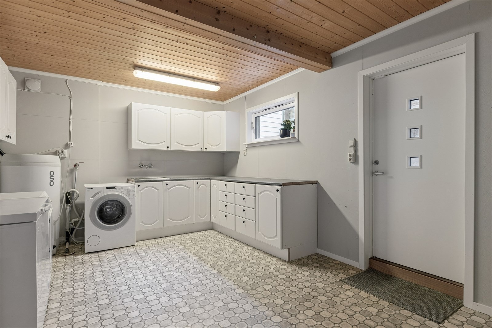 Rom innredet som vaskerom. Gulvbelegg. Rommet har utslagsvask, opplegg for vaskemaskin og varmtvannsbereder. Egen utgang. Opprinnelig bod (tilleggsdel) er omgjort til vaskerom (hoveddel), ikke søkt godkjent. Galleribilde