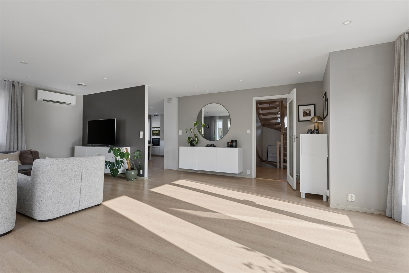 Gjennomgående gulv og lyse farger gir en helhetlig og rolig atmosfære i oppholdsrommene. Galleribilde