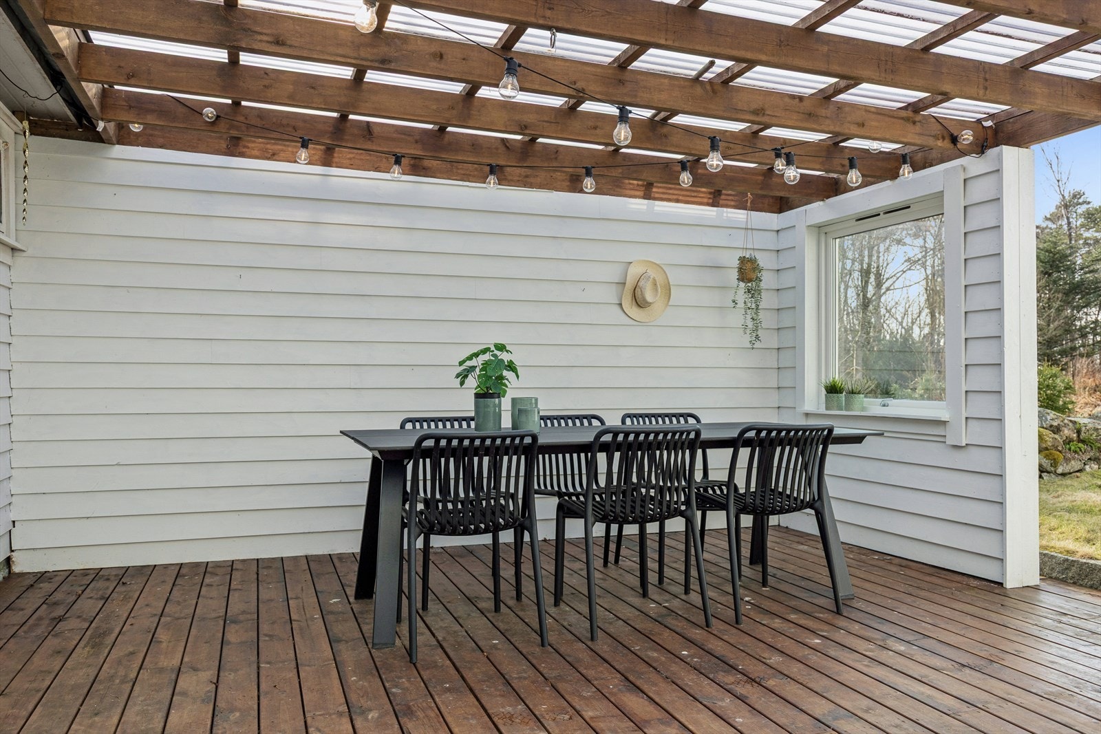 Trapp ned til en lun og usjenert uteplass med tak, perfekt for sosiale sammenkomster. Galleribilde